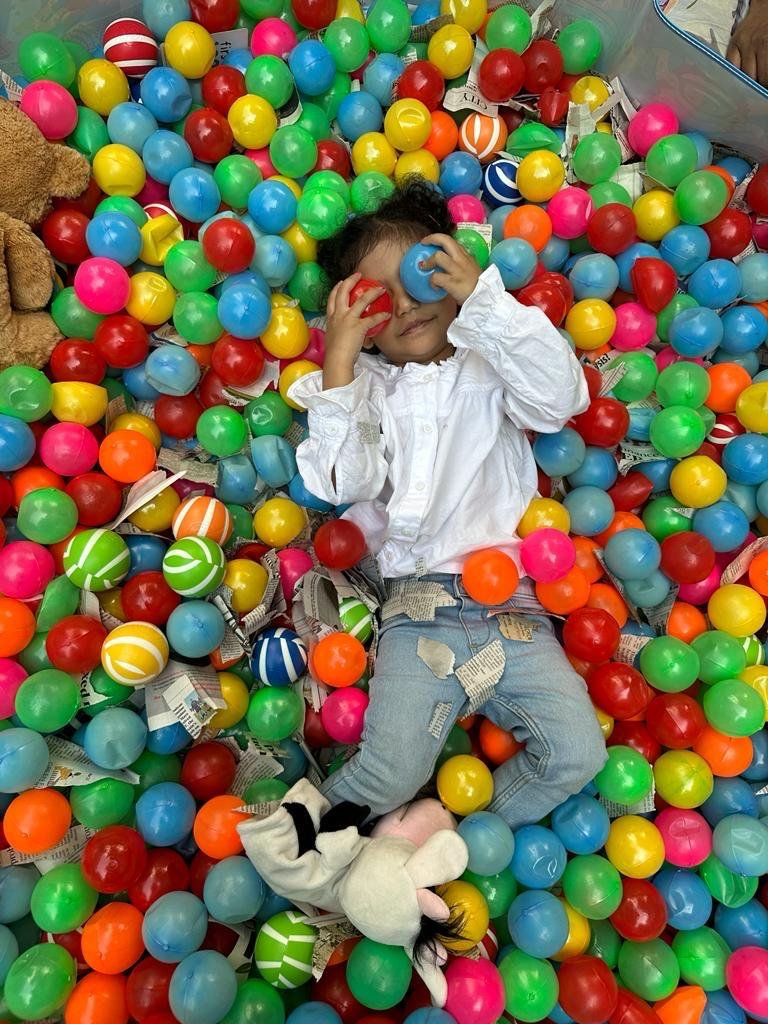 Preschool child playing in colorful ball pit at Dandelionz in Dhaka